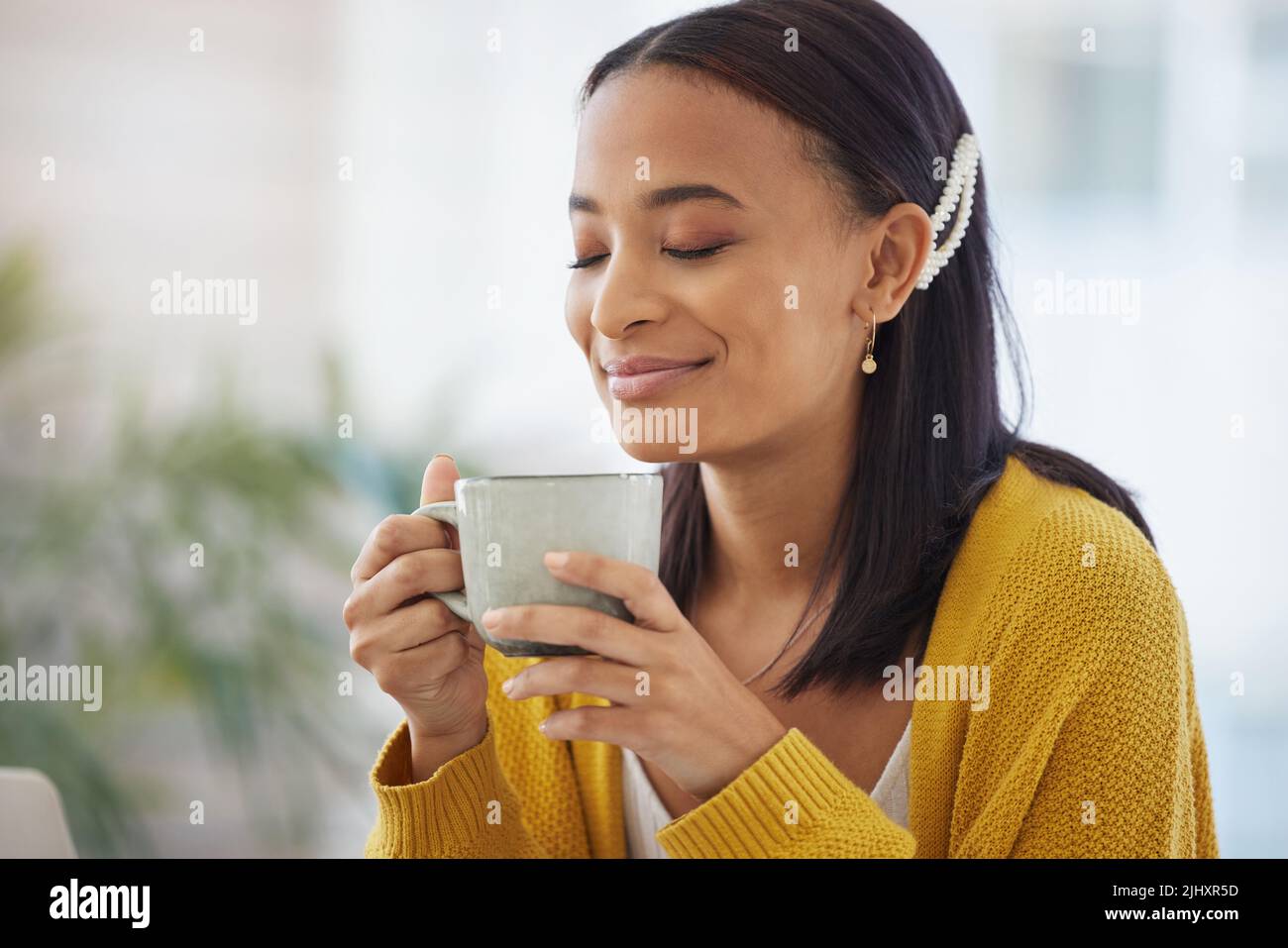 Whats a day without coffee. a young woman drinking coffee at home Stock