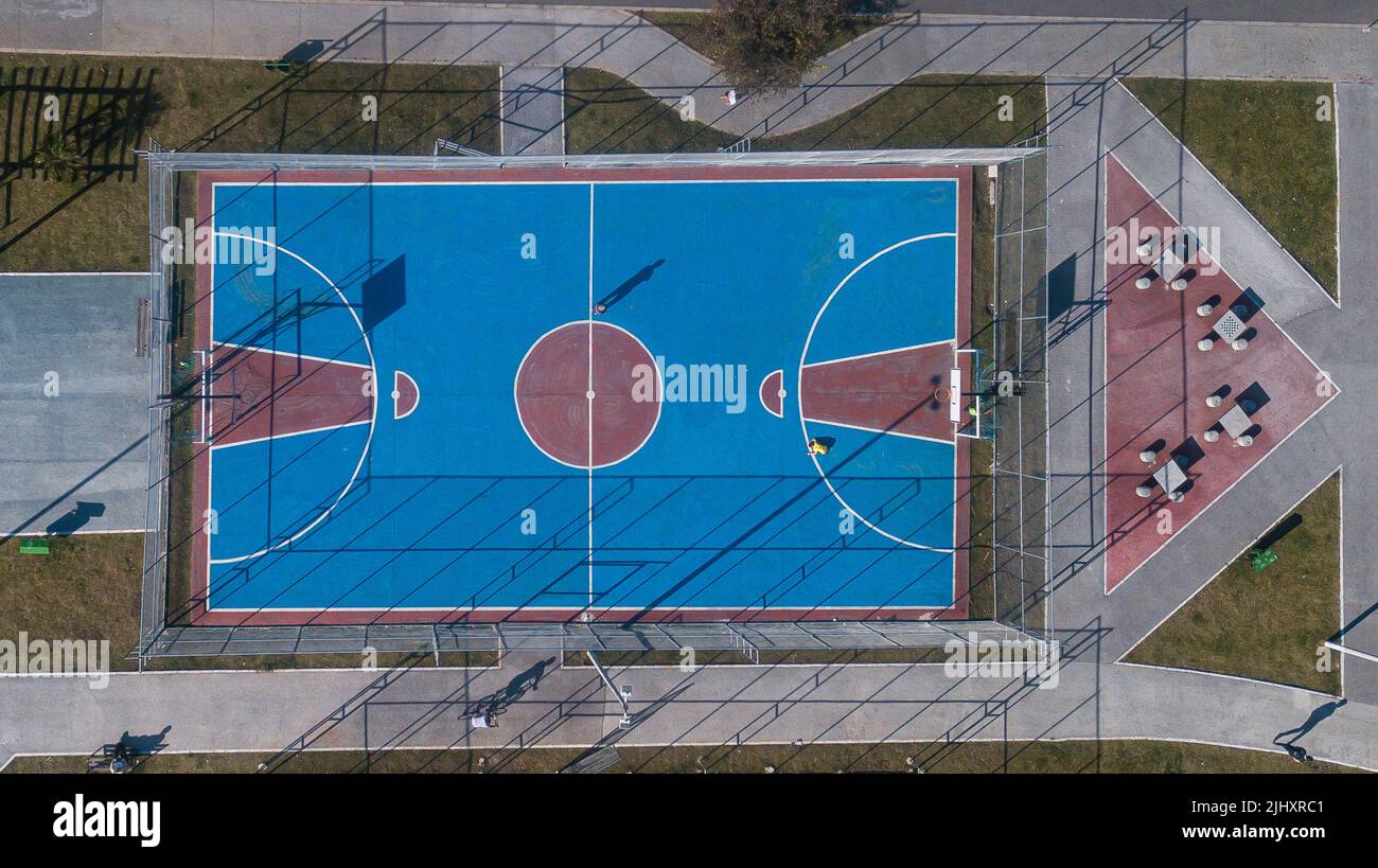 Outdoor sports frame in red and blue colors, top view with drone, of various sports, including basketball, volleyball and indoor soccer. Stock Photo