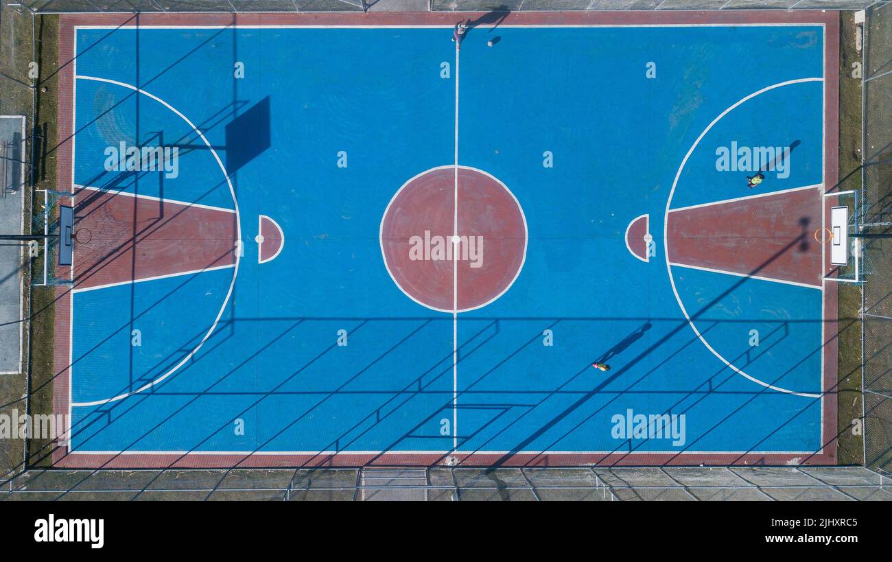 Outdoor sports frame in red and blue colors, top view with drone, of various sports, including basketball, volleyball and indoor soccer. Stock Photo