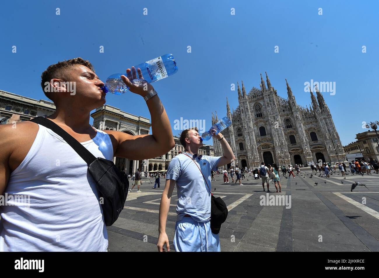 Men drink water by the Milan's Duomo cathedral at Duomo square, as  temperatures soar during a heatwave in Milan, Italy, July 21, 2022. REUTERS/ Massimo Pinca Stock Photo - Alamy