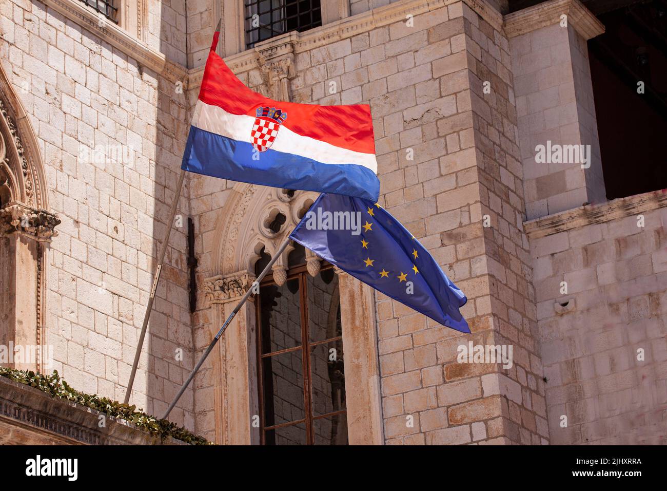 Croatian and EU European Union flags waving from building in old town of Dubrovnik. Croatia is the youngest country that joined the European Union in Stock Photo