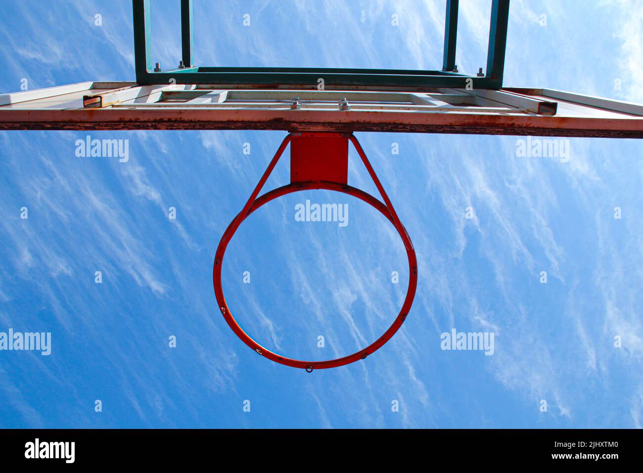 Basketball ring on the background a blue sky with white clouds. Basketball hoop on a shield on
