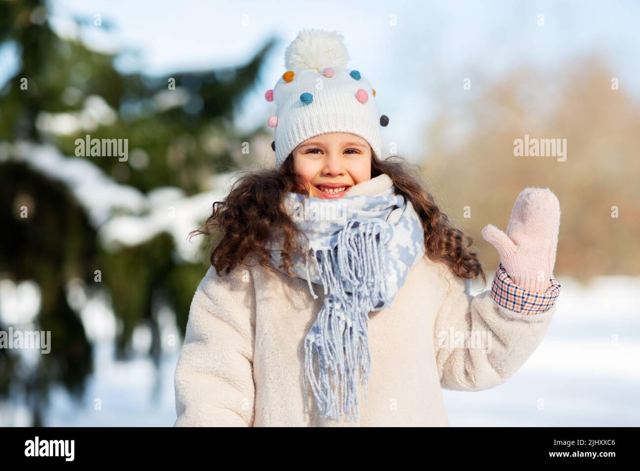 happy little girl waving hand outdoors in winter Stock Photo