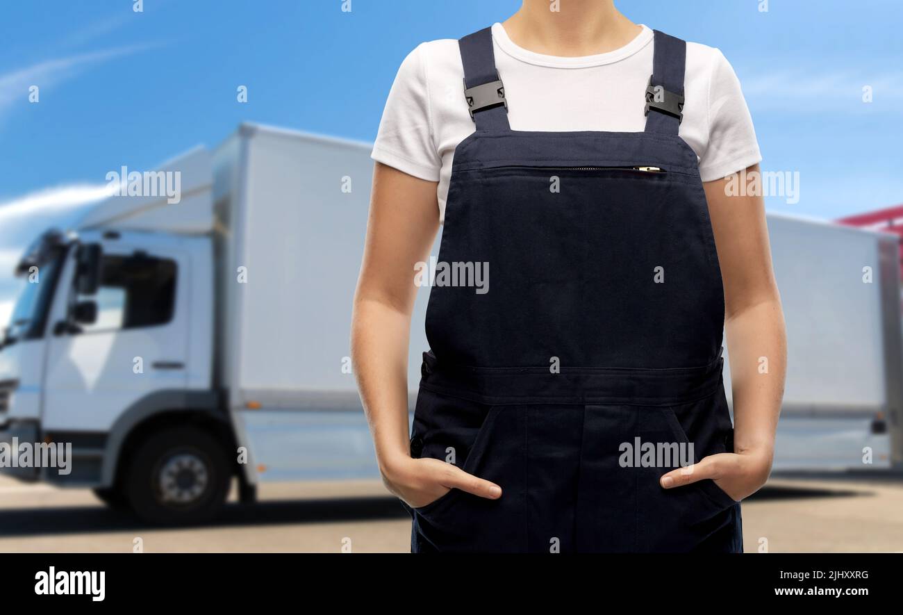 close up of female worker in overall over truck Stock Photo