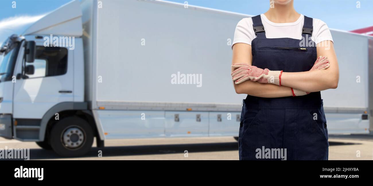close up of female worker in overall over truck Stock Photo