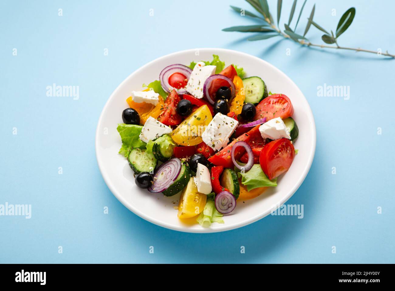 Overhead view of Greek salad on plate on blue surface healthy food Stock Photo