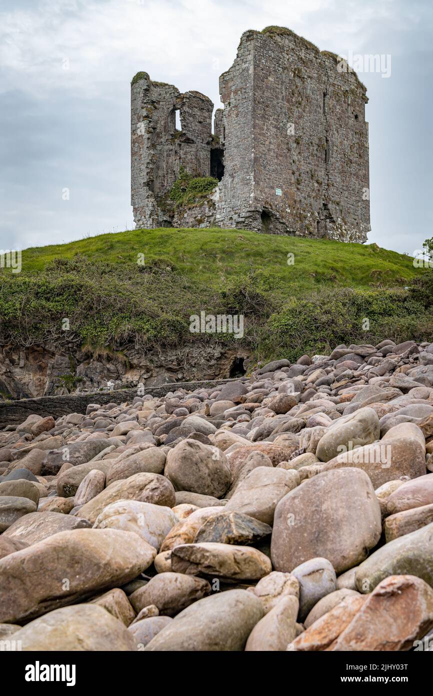 The remains of Minard Castle from the rocky sea wall at Minard Beach, County Kerry, Ireland Stock Photo