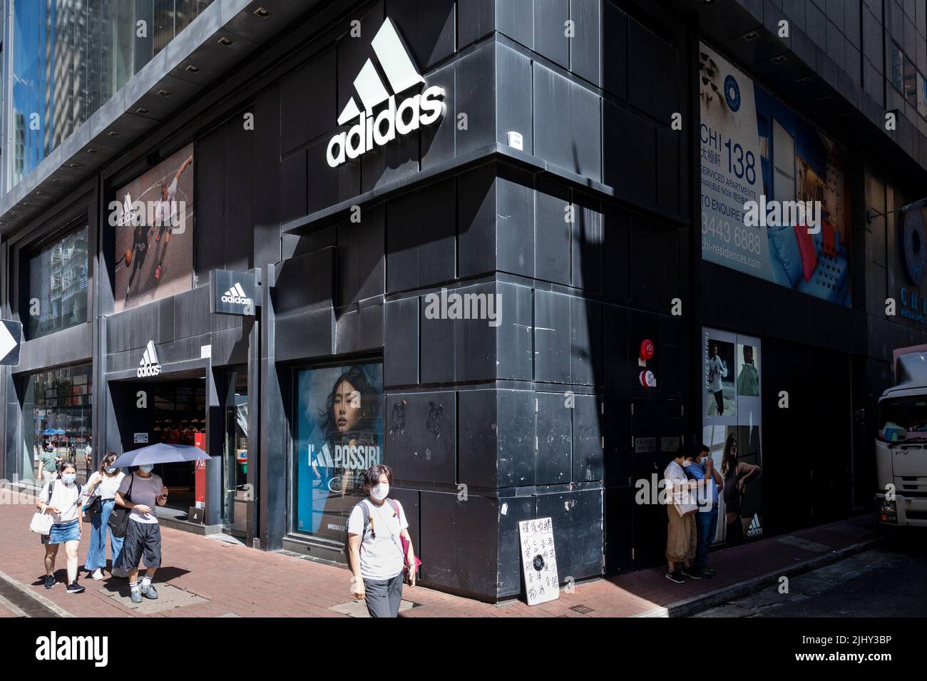 Pedestrians walk past the German multinational sportswear brand Adidas
