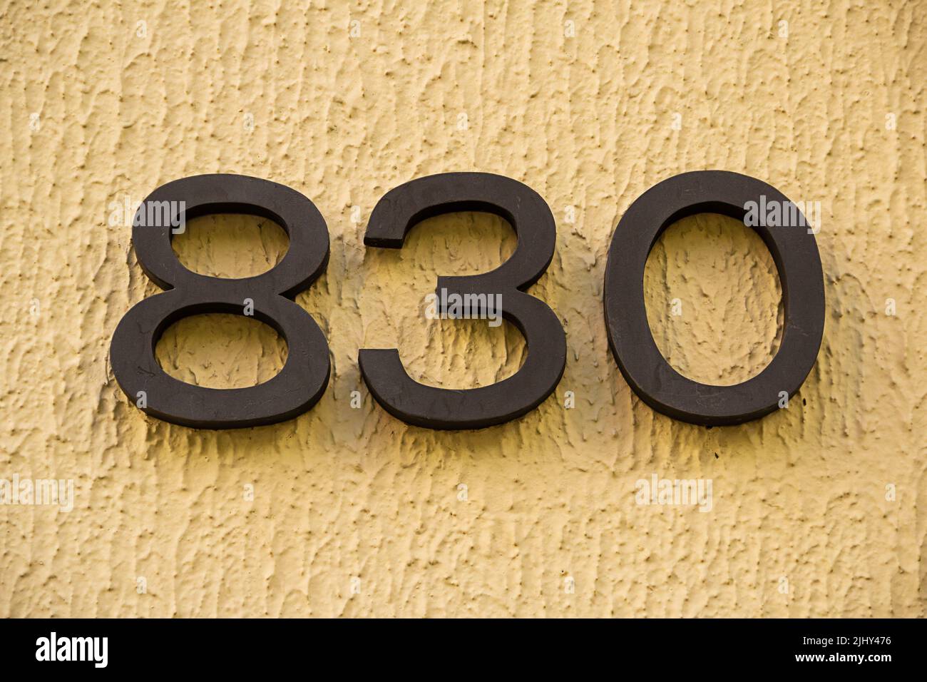 Goiania, Goiás, Brazil – July 20, 2022: Number eight hundred and thirty in metal nailed to the wall of a building. 830. Stock Photo