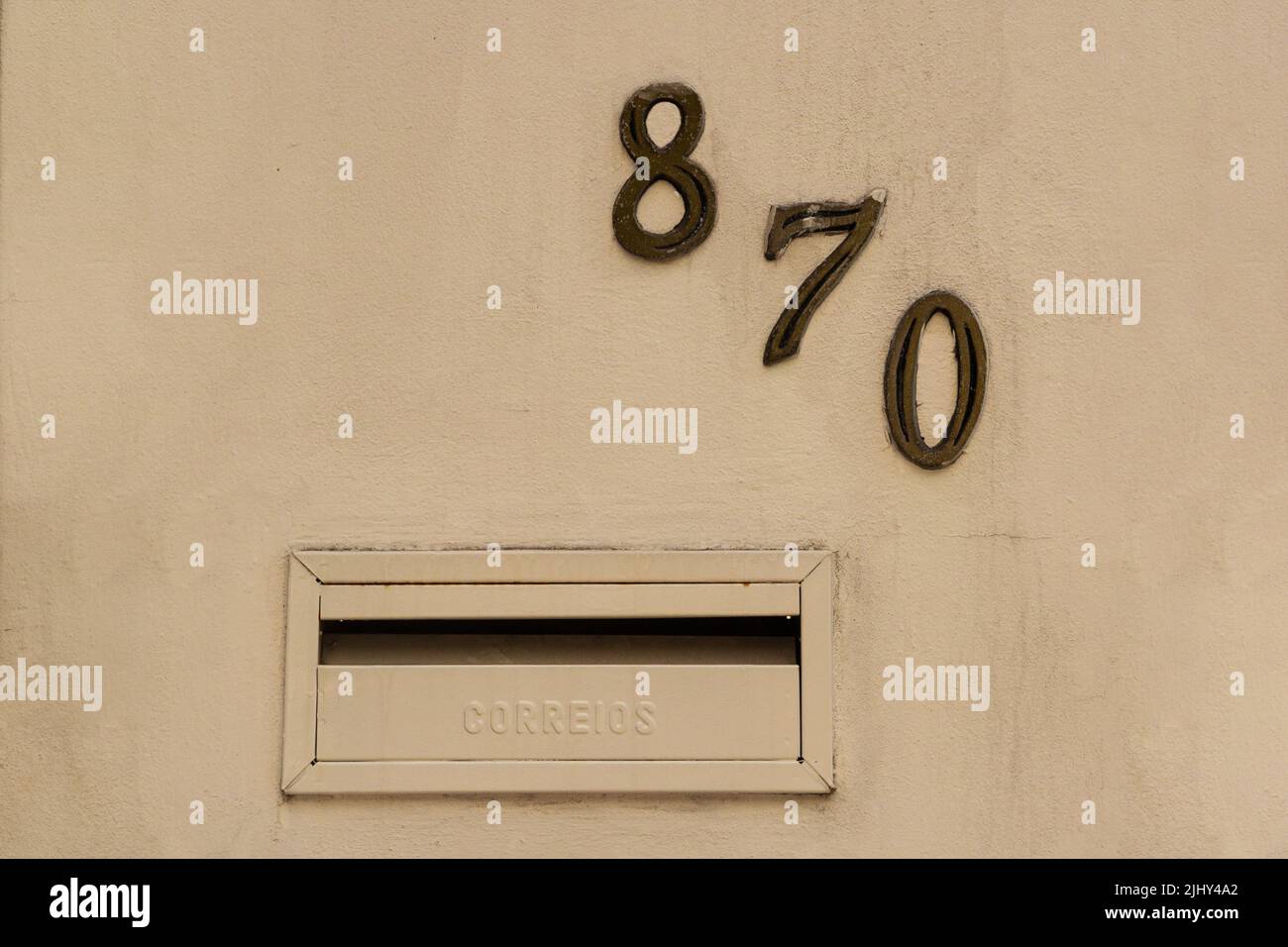 Goiania, Goiás, Brazil – July 20, 2022:  Number eight hundred and seventy in metal nailed to the wall of a building. 870. Stock Photo