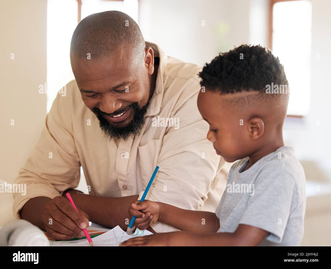African american boy doing homework with his dad. A handsome black man helping his son with school work at home. Its important to learn and get an Stock Photo