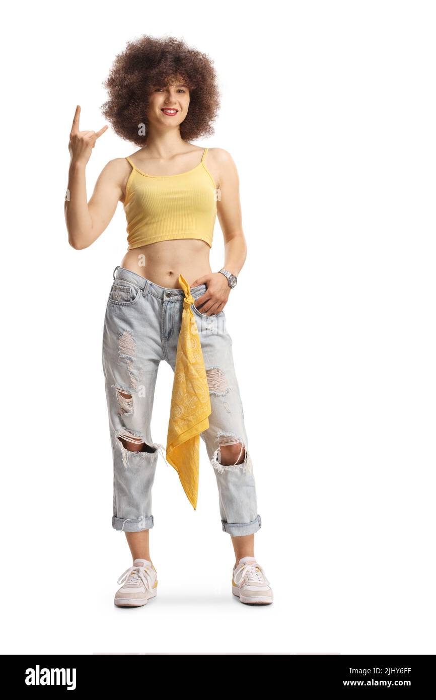 Full length portrait of a trendy young caucasian female with afro hairstyle gesturing a rock and roll sign isolated on white background Stock Photo