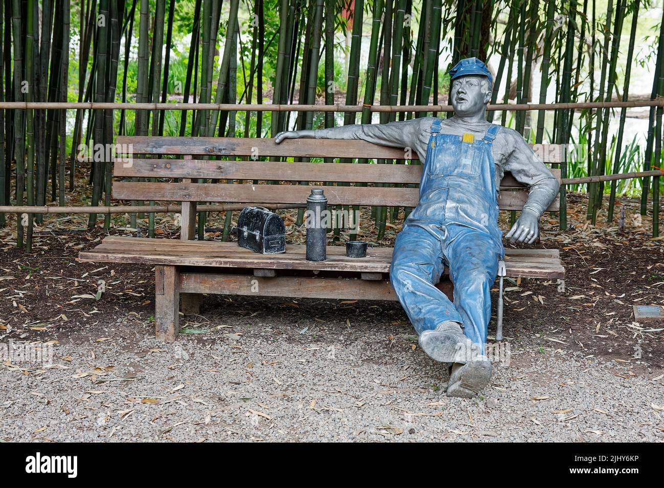 man sitting on bench, in work clothes, lunch; large  bronze sculpture, Grounds for Sculpture; Seward Johnson Center for the Arts; New Jersey; Hamilton Stock Photo
