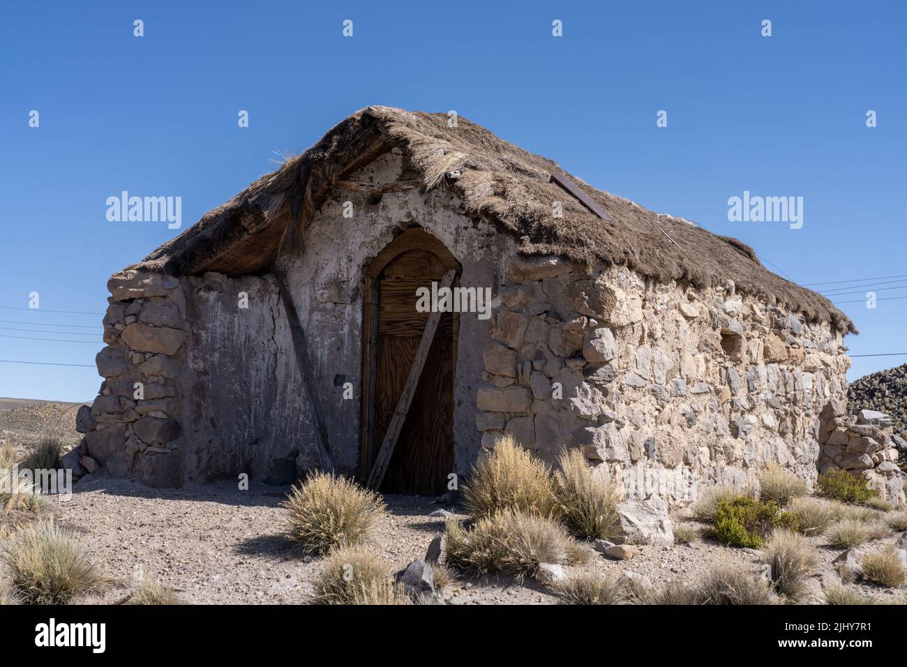 An abandoned stone cottage with a thatched roof in Lauca National Park on the high Andean altiplano in Chile. Stock Photo