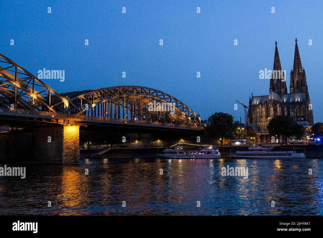 The Hohenzollern Bridge and Cologne Cathedral at dusk from the Rhine River, Cologne, Germany Stock Photo