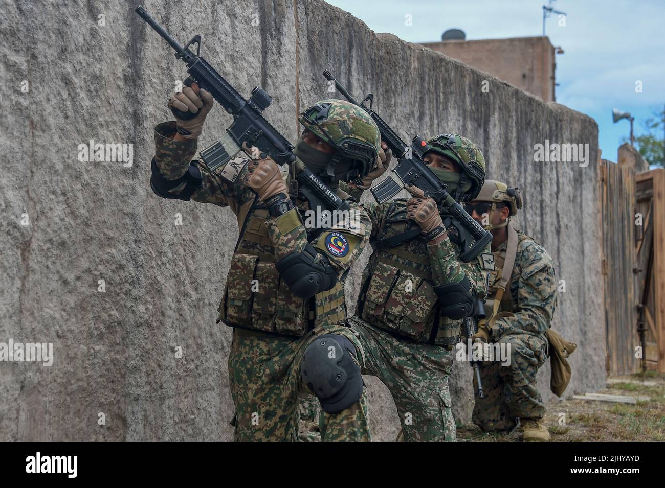Waimanalo, United States. 18 July, 2022. Malaysian Army soldiers and a U.S. Marine provide cover during a simulated urban terrain warfare exercise during the Rim of the Pacific exercises, July 18, 2022 in Bellows Air Force Station, Hawaii. Credit: MCS Leon Vonguyen/U.S. Navy/Alamy Live News Stock Photo