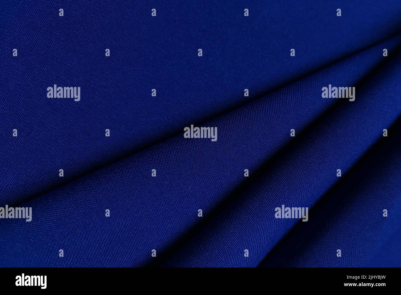 Blue crumpled or wavy fabric texture background. Abstract linen cloth soft waves. Gabardine wool fabric. Merino yarn. Smooth elegant luxury cloth Stock Photo