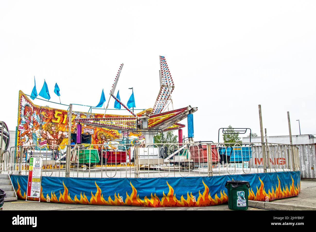 2022-06-25 Anchorage Alaska USA Carnival ride - Sizzler whiling seats in brightly colored ride with flags and neon lights and outdoor fun fair - Room Stock Photo