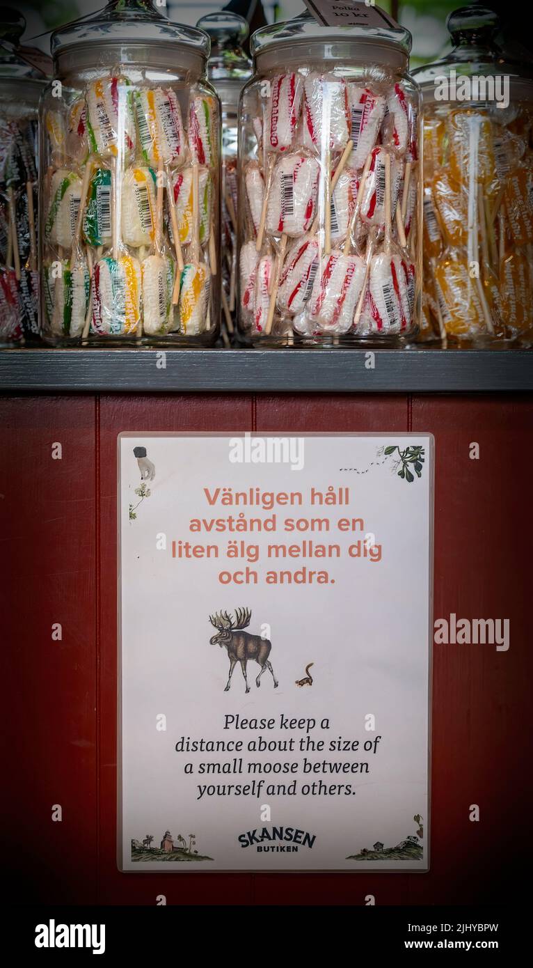 glass jars with sweeties and an information sign to hold a distance of the size of a small moose in a shop at Stockholm, Sweden Stock Photo