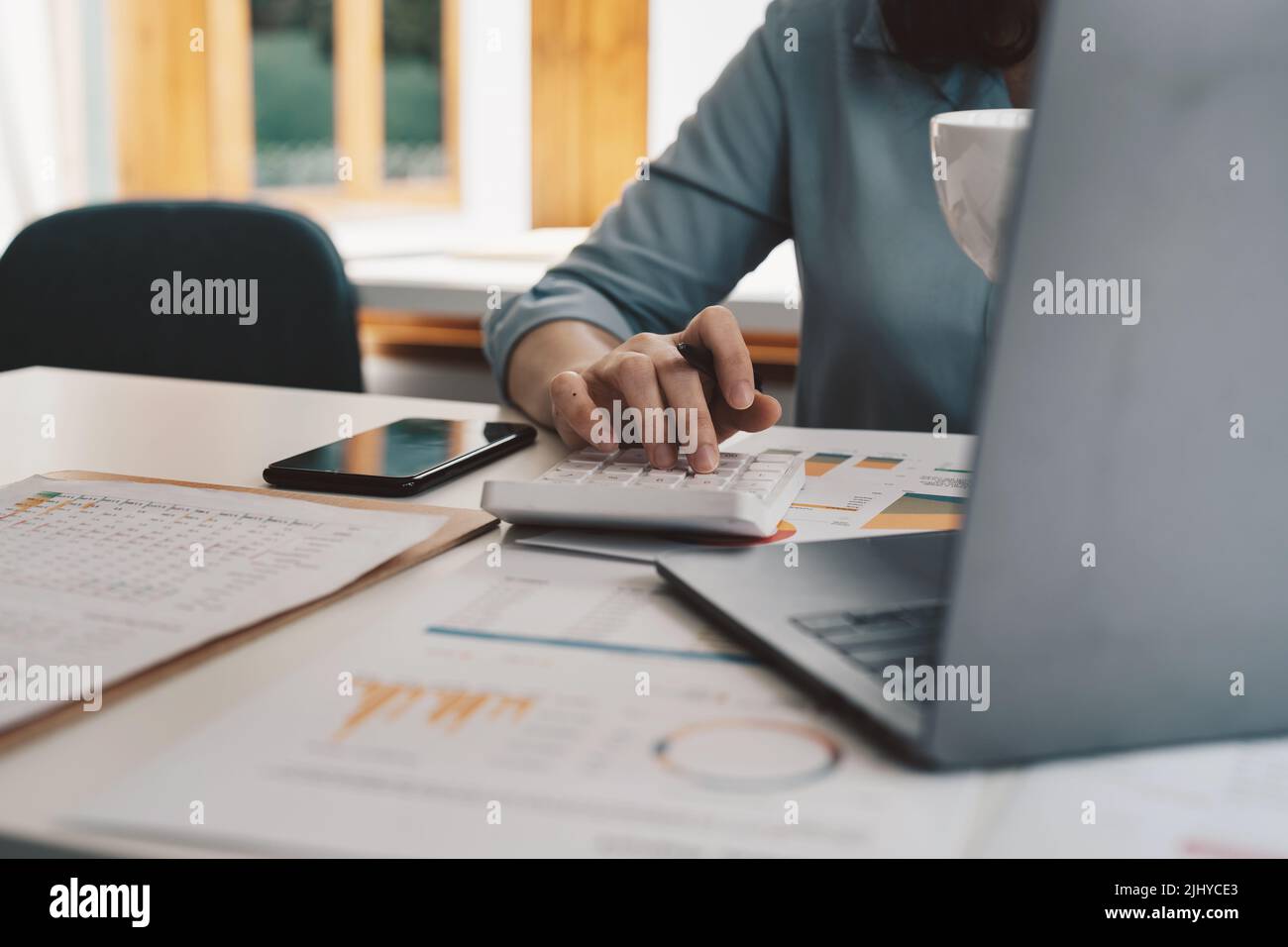 Accounting businesswomen are calculating income-expenditure and analyzing real estate investment data, Dedicated to the progress and growth of the Stock Photo