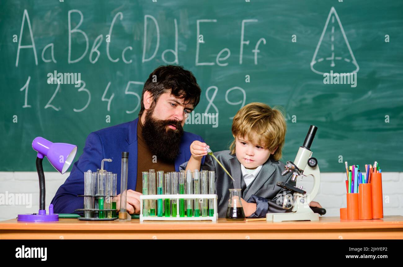 laboratory research and development. father and son child at school. bearded man teacher with boy. lab test tubes and flasks with colored liquids Stock Photo