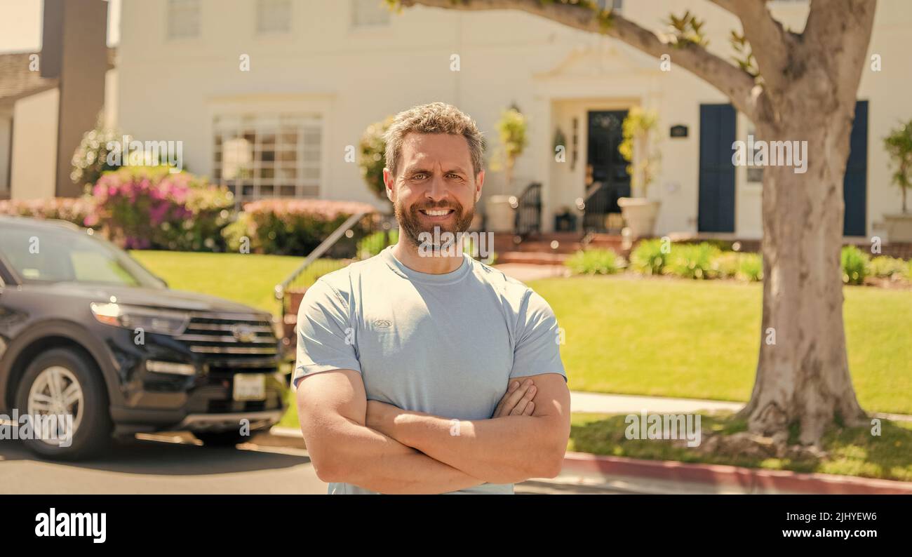 cheerful salesman presenting suburb house and car. broker Stock Photo