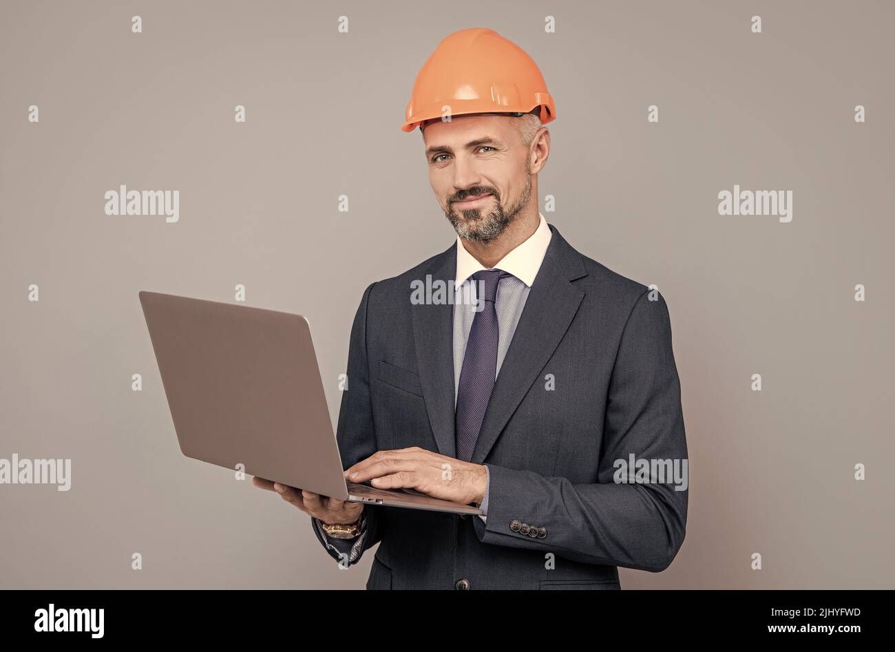 businessman man in building helmet texing message on laptop, business communication Stock Photo