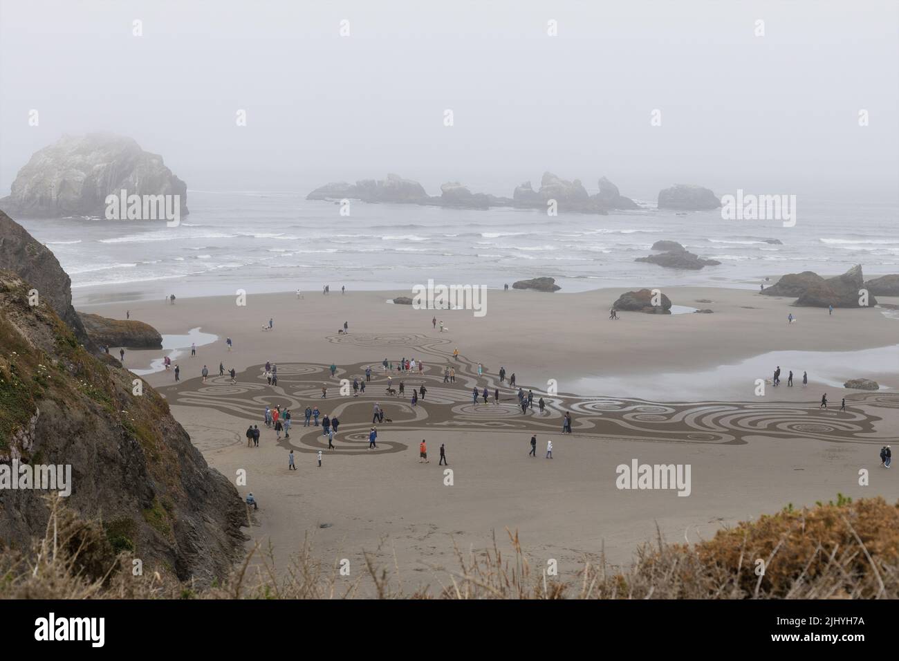 People walking a Circles in the Sand labyrinth on Face Rock Beach in ...