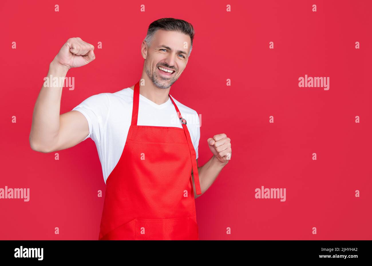 mature barman in apron on red background Stock Photo