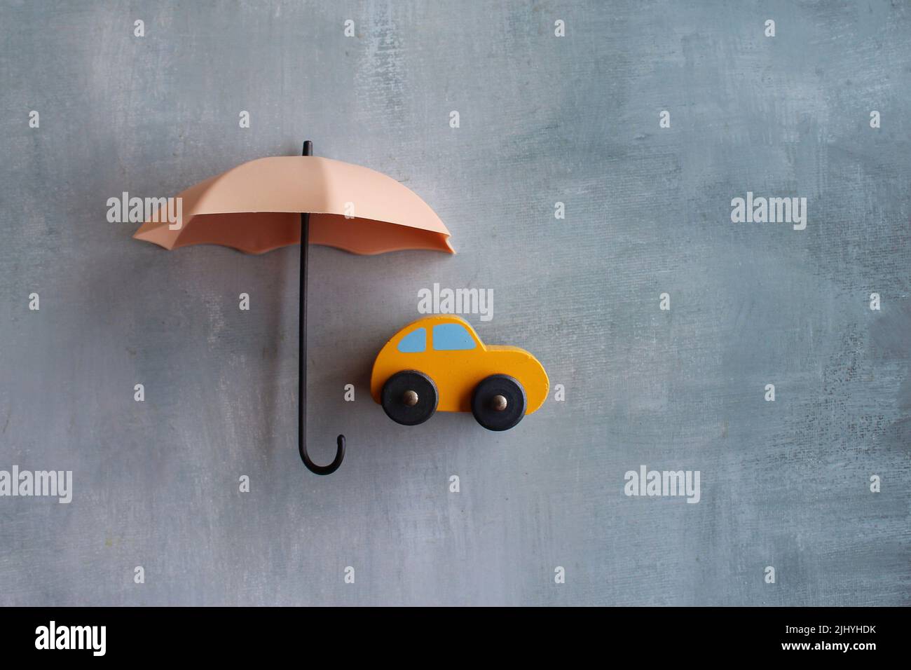 Umbrella and toy car with copy space. Car protection and insurance