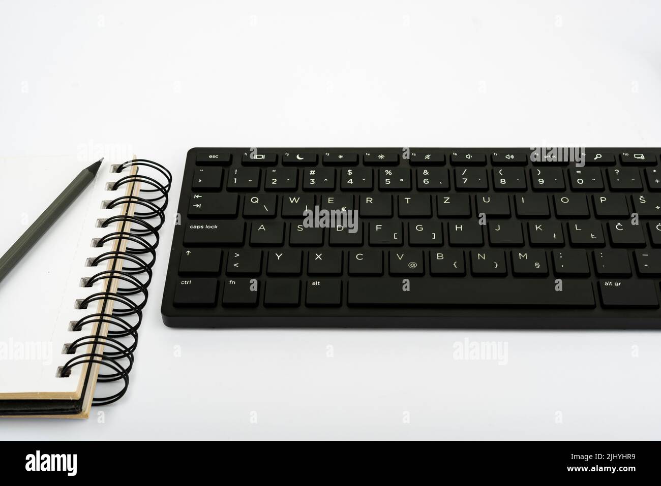 A lowangle view of a workspace with a computer keyboard, a spiral