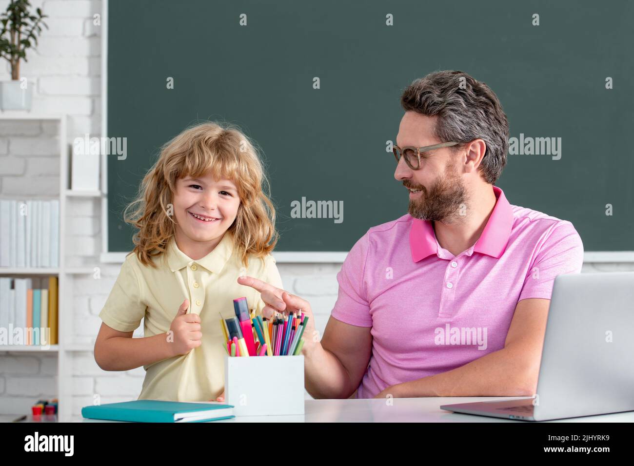 School teacher with a schoolboy. Teacher and students in the classroom ...