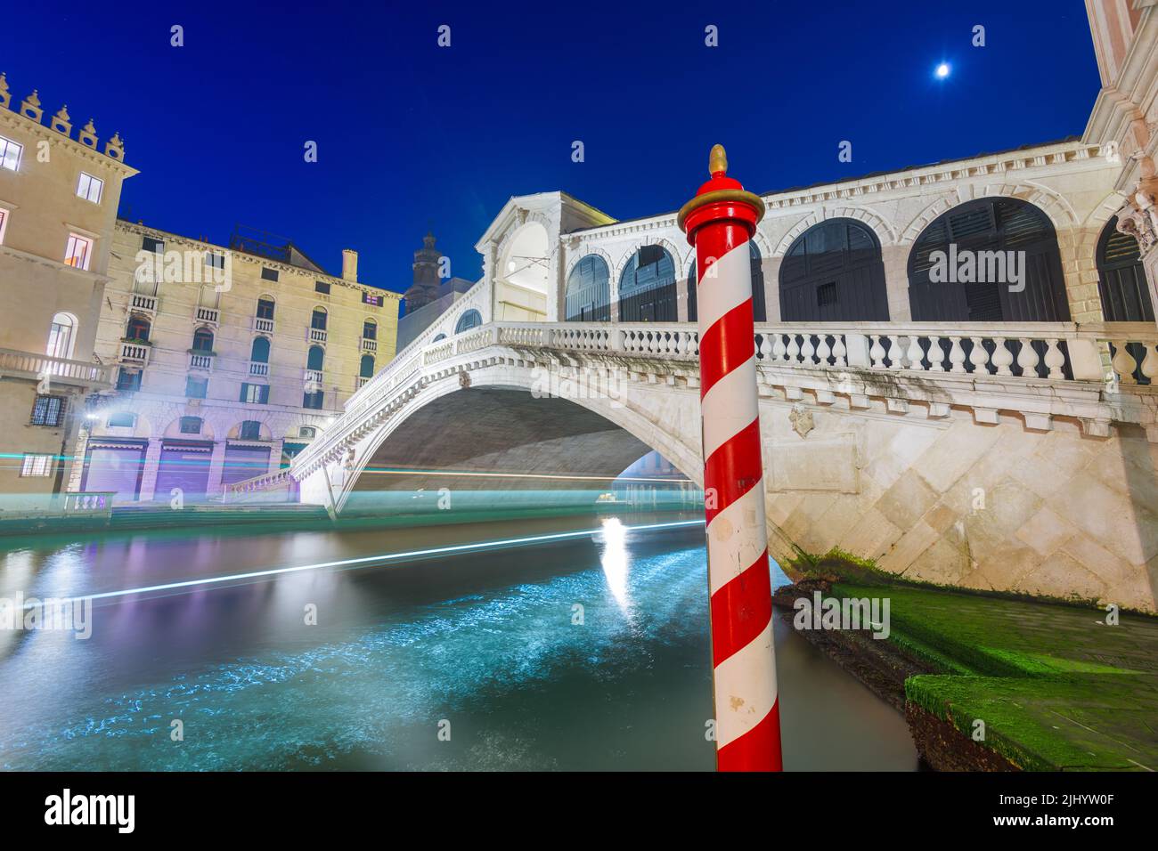 Venice, Italy with light trails on the Grand Canal passing under the Rialto Bridge at night. Stock Photo