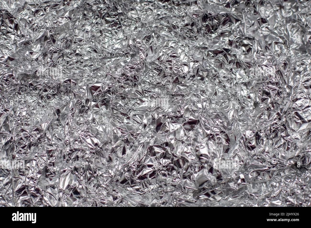 crumpled aluminium foil flat background and texture. Stock Photo