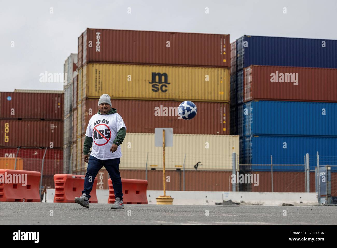 A truck driver plays soccer as he joins a gathering to block the entrance of trucks at a container terminal at the Port of Oakland, during a protest against California's law known as AB5, in Oakland, California, July 21, 2022. REUTERS/Carlos Barria Stock Photo