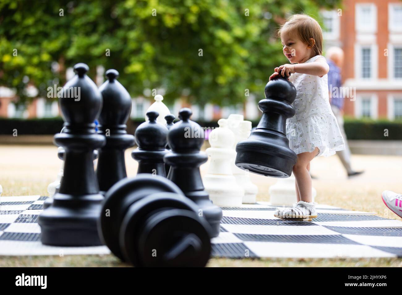 EDITORIAL USE ONLY Mia aged 17 months plays chess at the opening of this year's Summer in the Square at Grosvenor Square in Mayfair, London. Picture date: Thursday July 21, 2022. Stock Photo