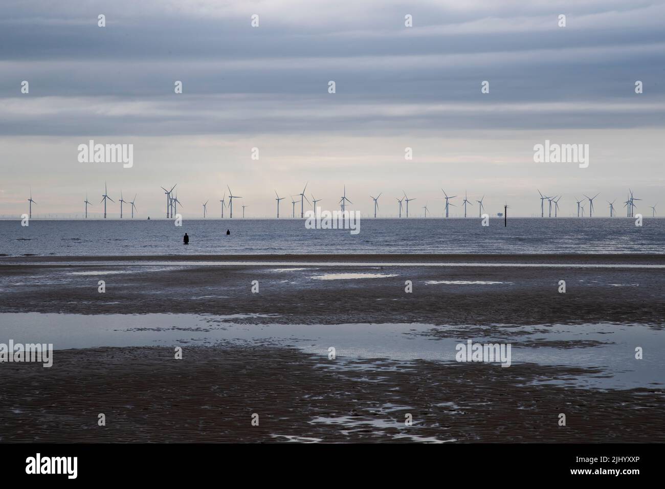 Banks of Off shore wind farms at Crosby beach in Merseyside generating renewable energy with Antony Gormley statues visible in the sea Stock Photo