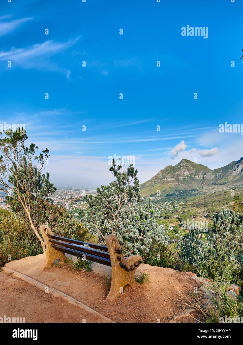 Bench with a beautiful view of Table Mountain and sea against a clear blue sky background with copy space. Relaxing spot for a peaceful break to enjoy Stock Photo