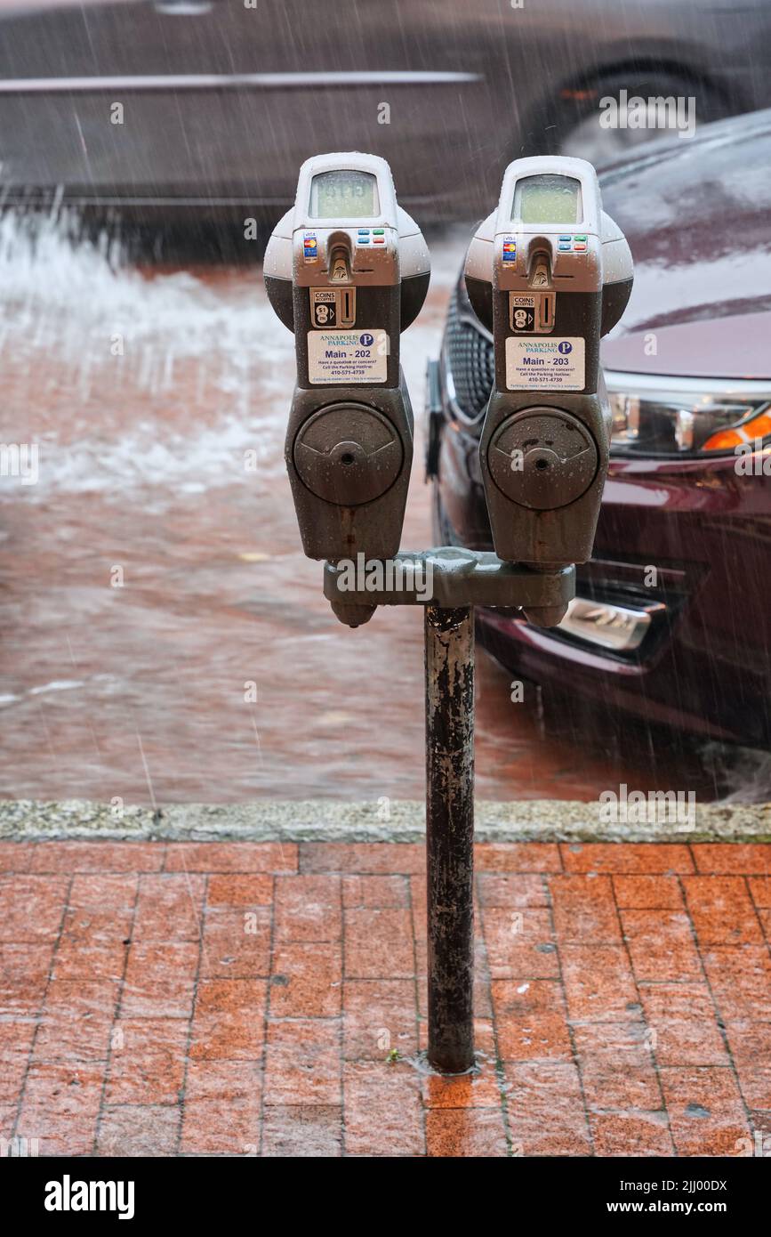 Parking meter on flooded street during heavy rainfall. Summer rain in downtown Annapolis, Maryland, United States. Stock Photo