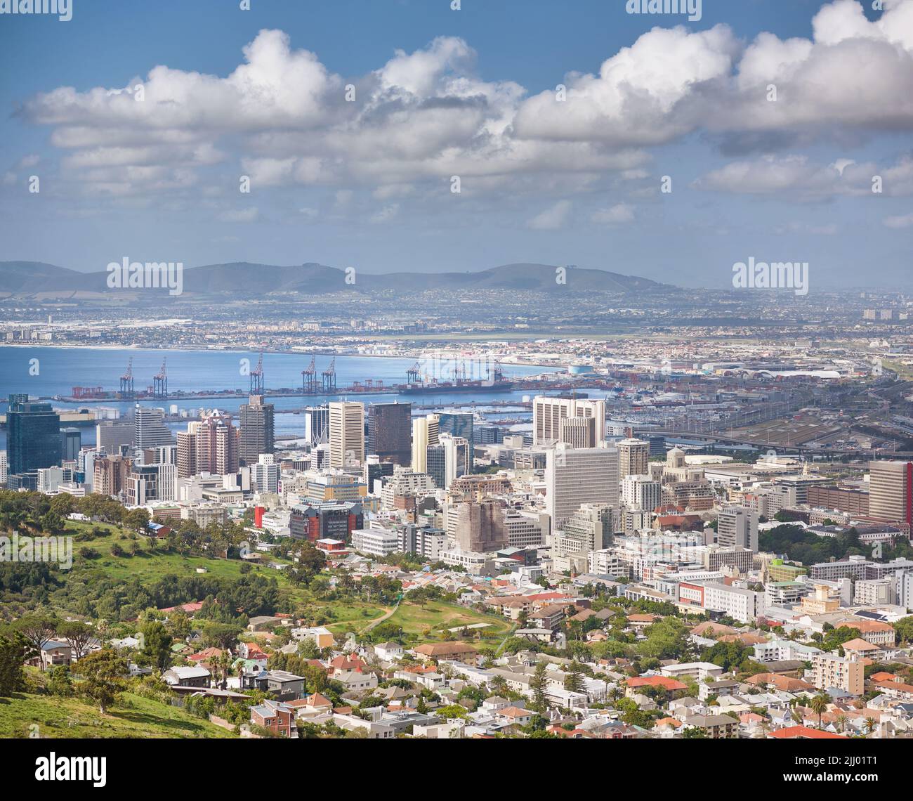 Landscape of buildings in an urban town with greenery along the mountain and sea. Copy space with views from Signal Hill in Cape Town, South Africa of Stock Photo