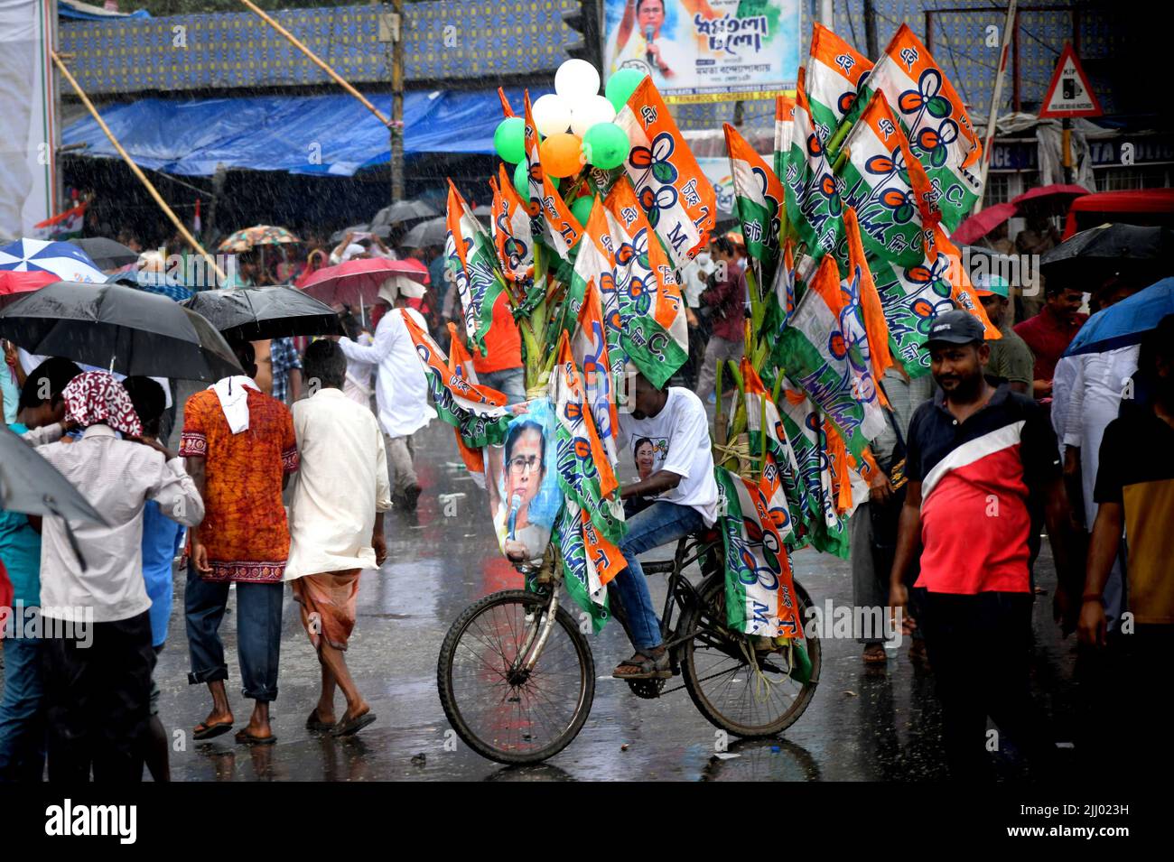 Kolkata, India. 21st July, 2022. A supporter rides a bicycle with flags of All India Trinamool congress, during the Rally. The 21st July Martyr's Day Rally is an annual mass rally organised by the All India Trinamool Congress to commemorate the 1993 Kolkata firing where 13 Congress workers lost their lives to the Police of CPIM Government. Credit: SOPA Images Limited/Alamy Live News Stock Photo