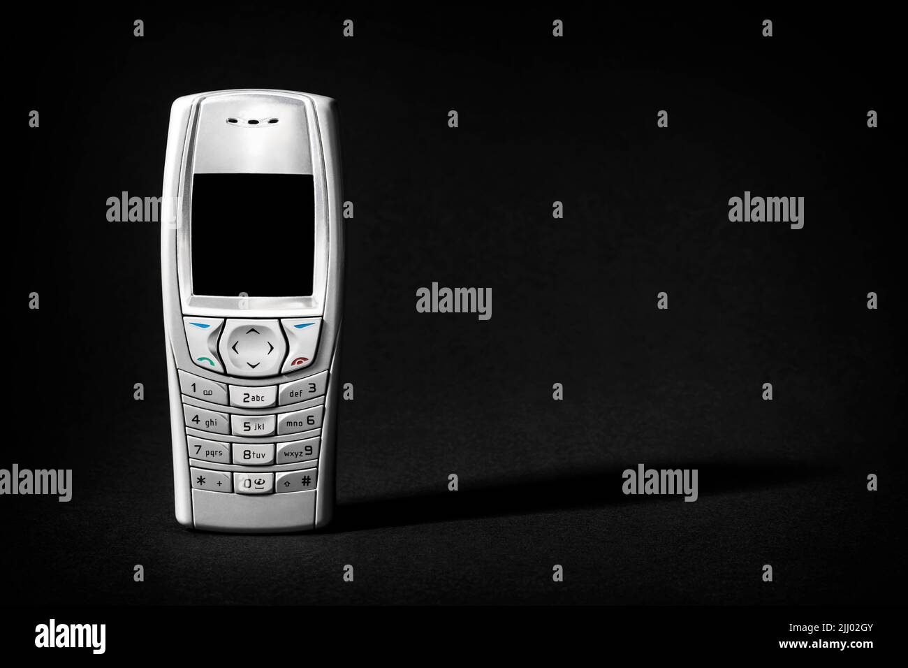 Old Silver Phone with buttons on black background. Stock Photo