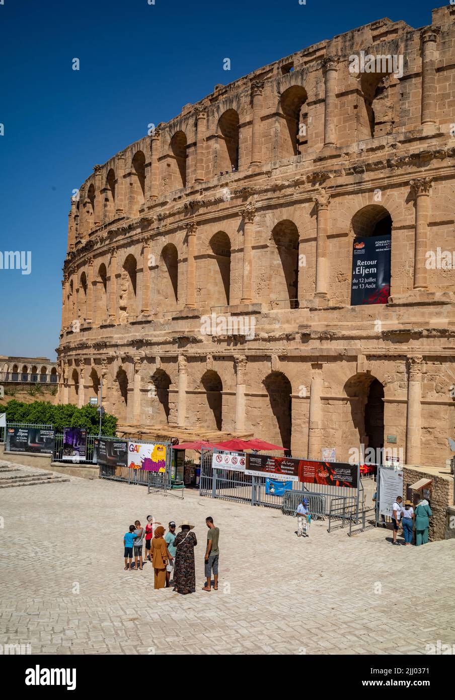 A group of tourists wait to visit the Roman amphitheatre in El Jem, Tunisia. Stock Photo