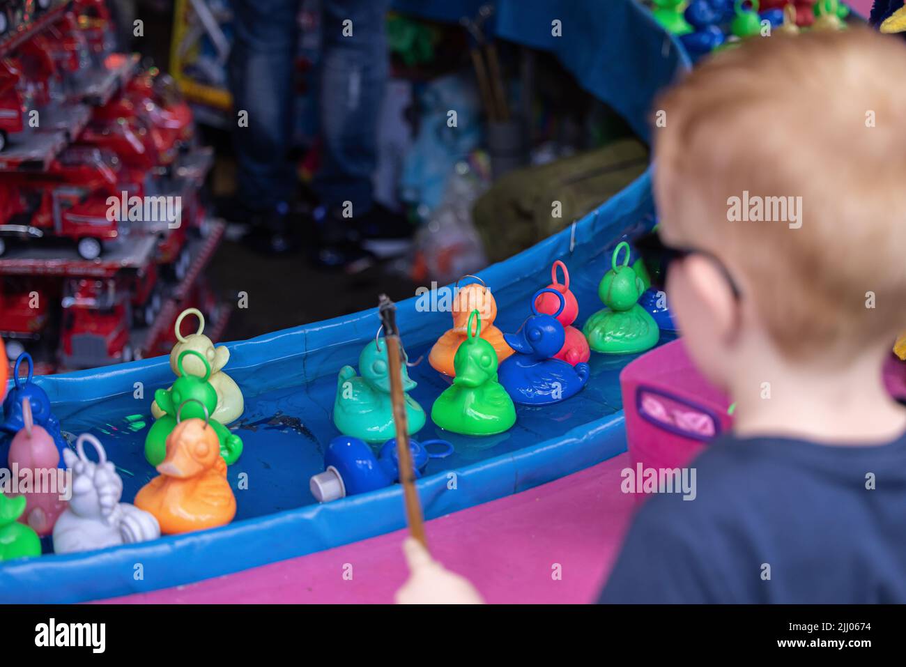 A boy with sunglasses playing a duck fishing minigame called Hooka