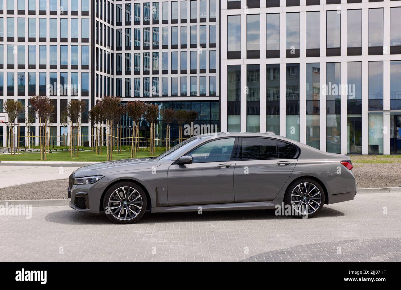 Grey BMW 740D xDrive in front of modern office buildings. G12 model 340 HP engine, acceleration 0-100 km-h - 5s. Katowice, Poland, 12.06.2021 Stock Photo