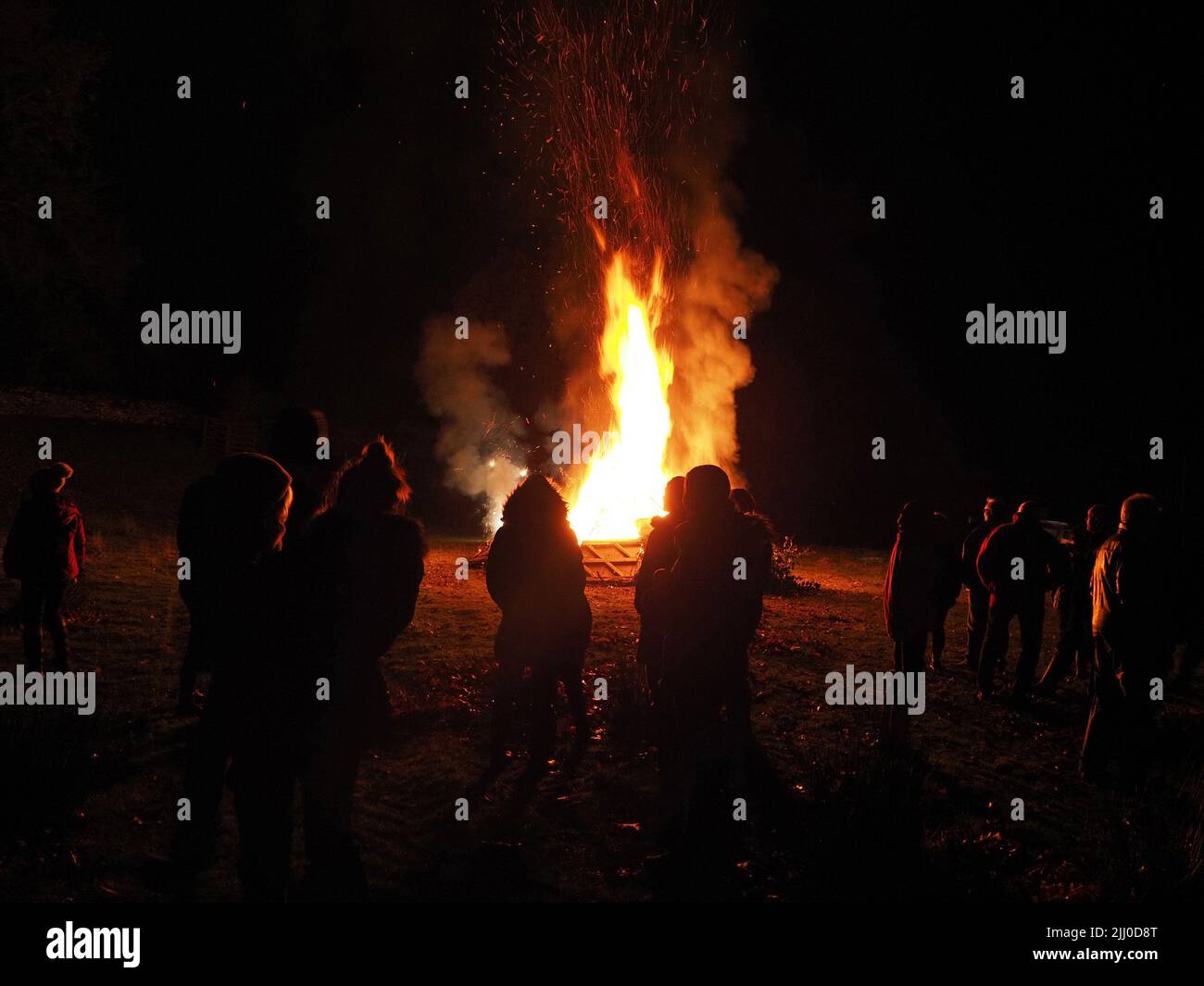 fireside silhouettes of unidentifiable people on Bonfire night - Cumbria, England, UK Stock Photo