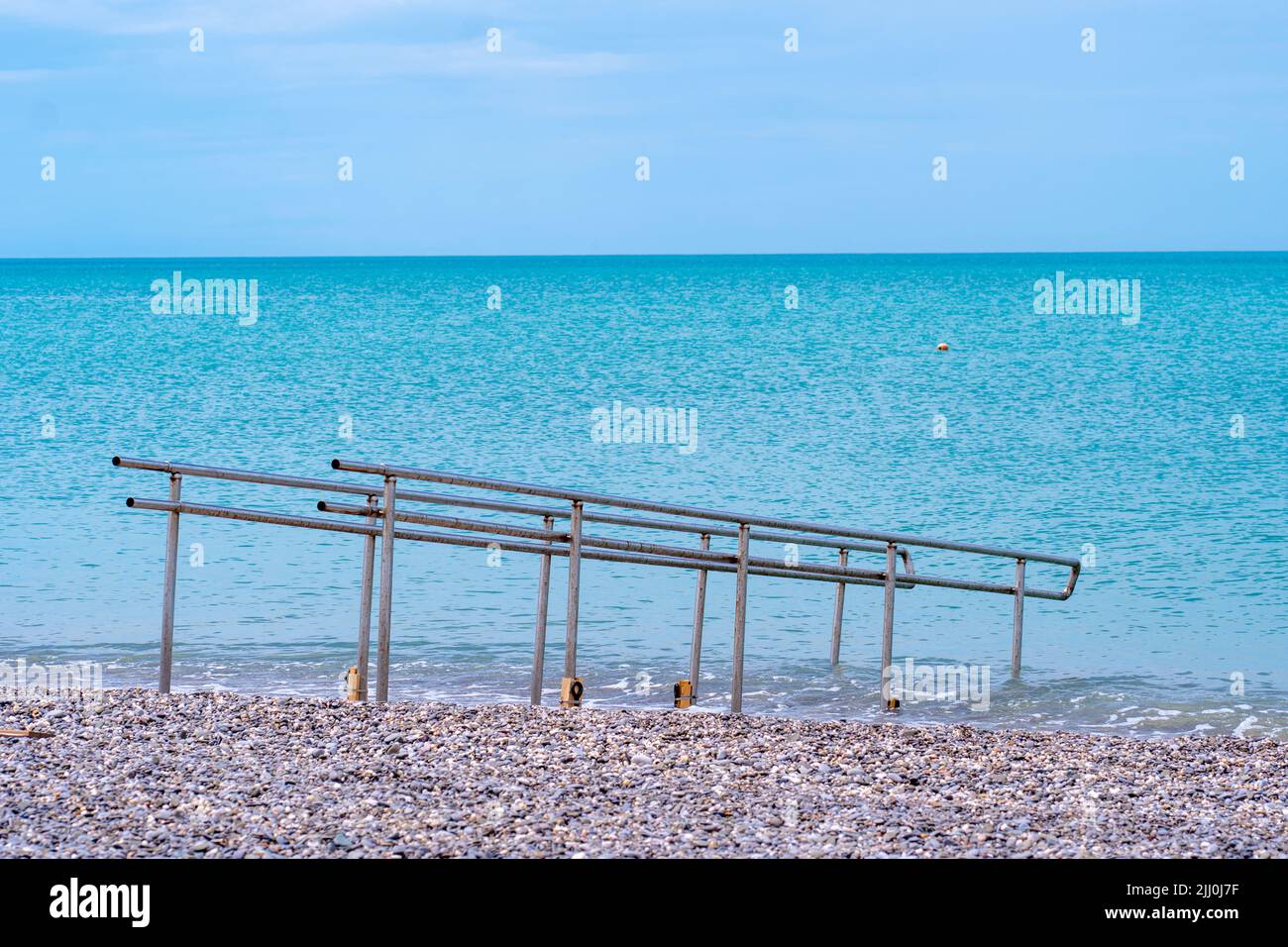 Handicapped chrome metal guard rail water outdoor sea structure background, concept waves coast from protection from handrail guarding, cormorant Stock Photo
