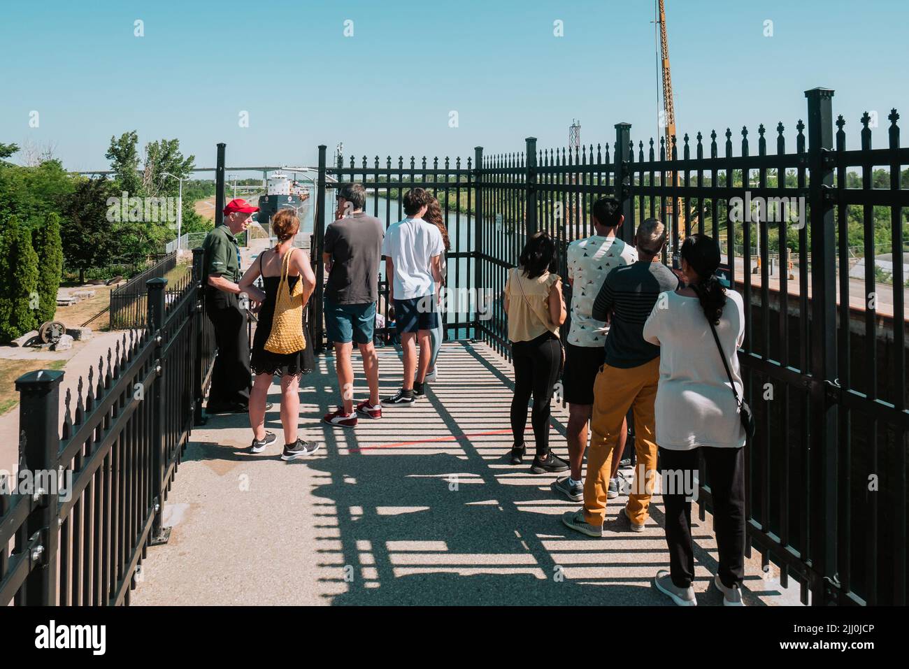tourists waiting at the wellland canal viewing area for the next cargo ship to arrive Stock Photo