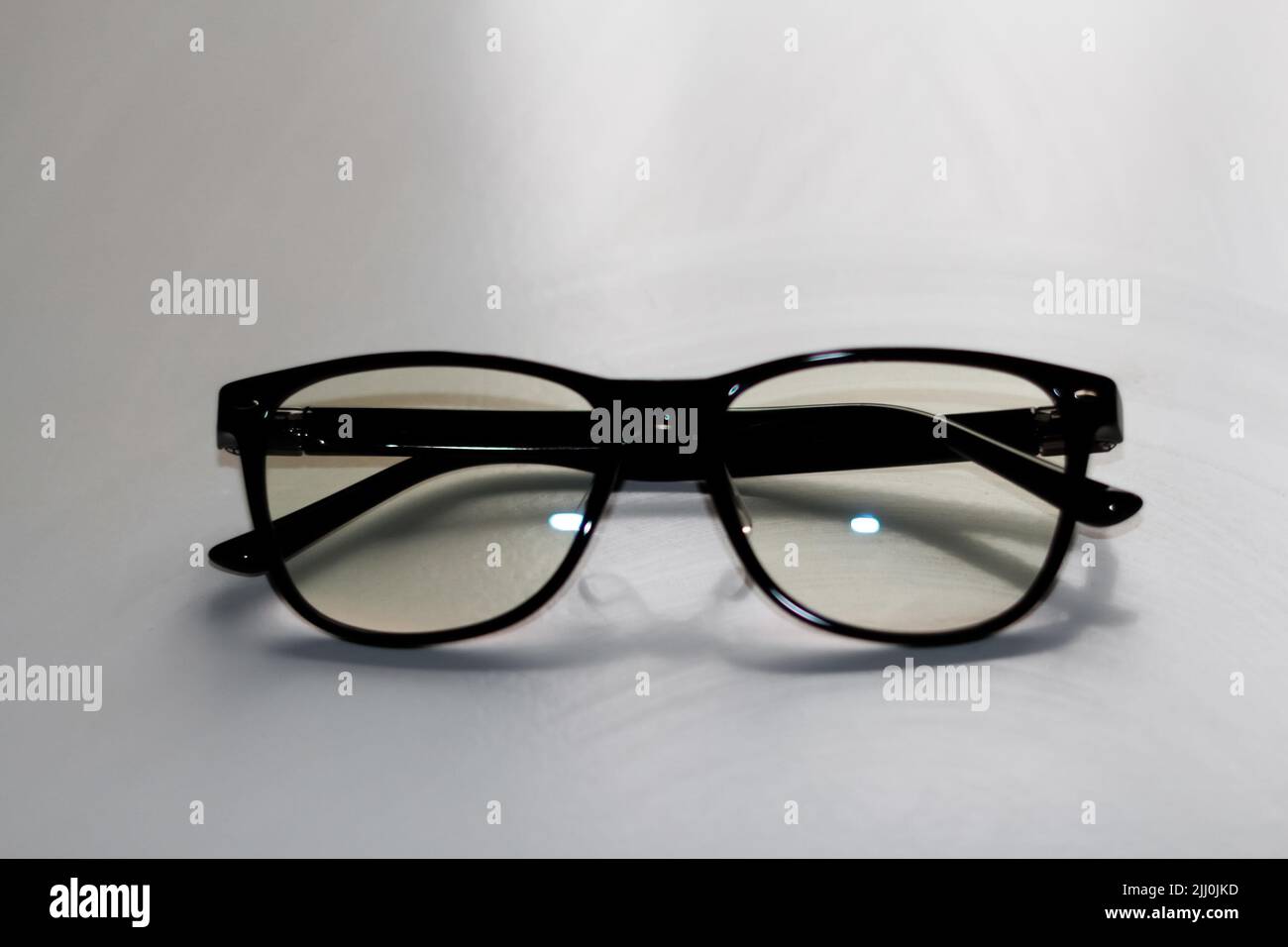 Defocus black eyeglasses on white background. Flat lay, top view. A ...