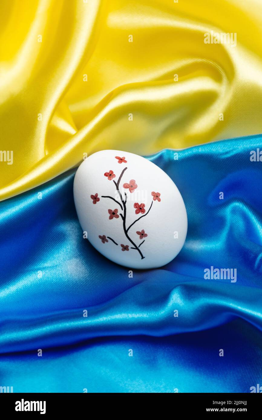 Vertical photo White Easter egg on the blue and yellow State Silk Flag ...